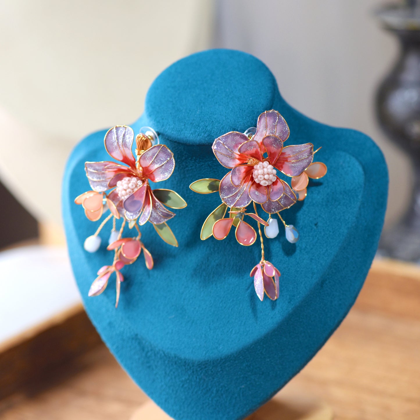 Adelei purple resin floral earrings with soft gold detail displayed on blue bust