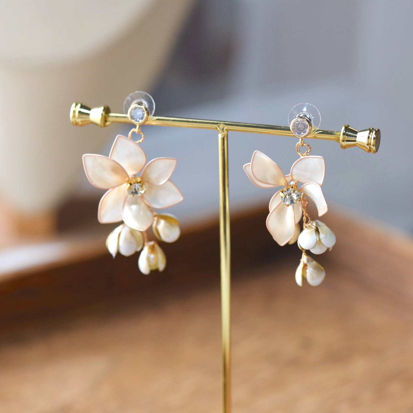 Amarille ivory and golden yellow resin floral bridal earrings on display stand
