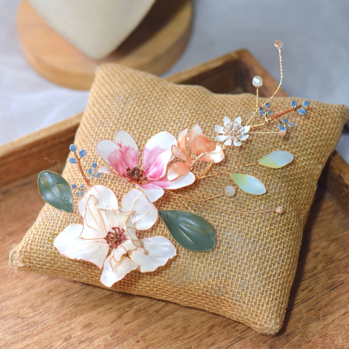 Close up of Aneira handcrafted floral hair accessory with pastel petals and gold detailing