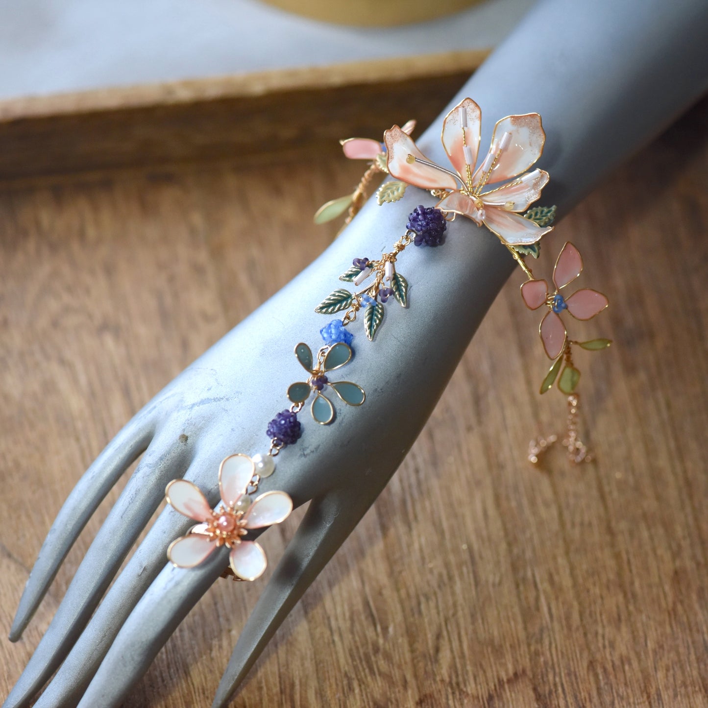 Close-up view of Candace floral hand harness showcasing layered resin flowers, bead accents and handcrafted gold wirework