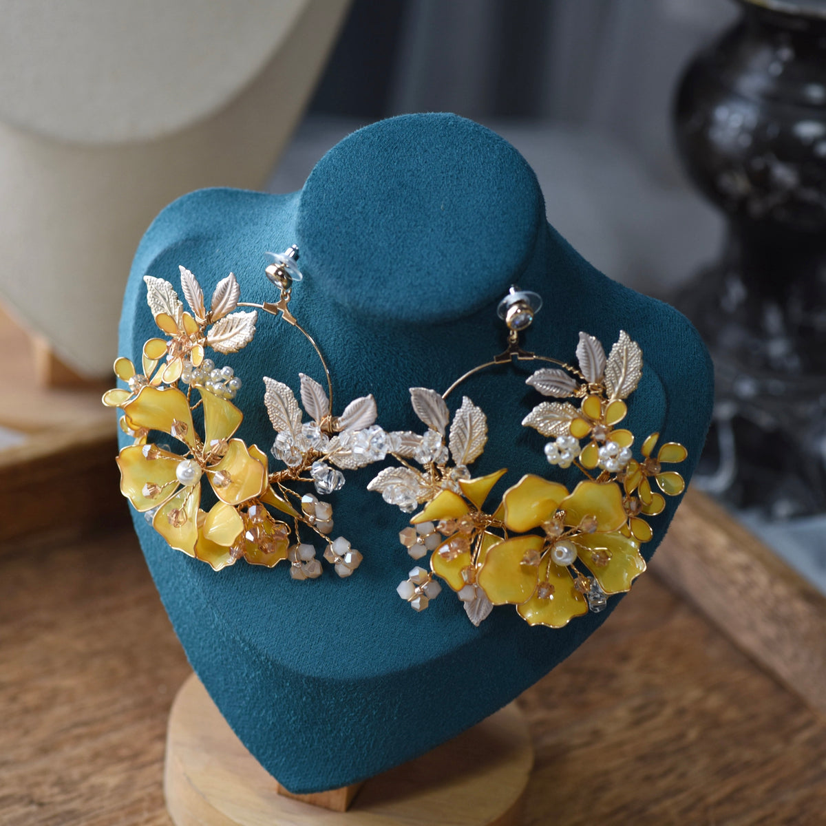 Helios yellow floral statement earringsfrom the jewellery set on a display stand