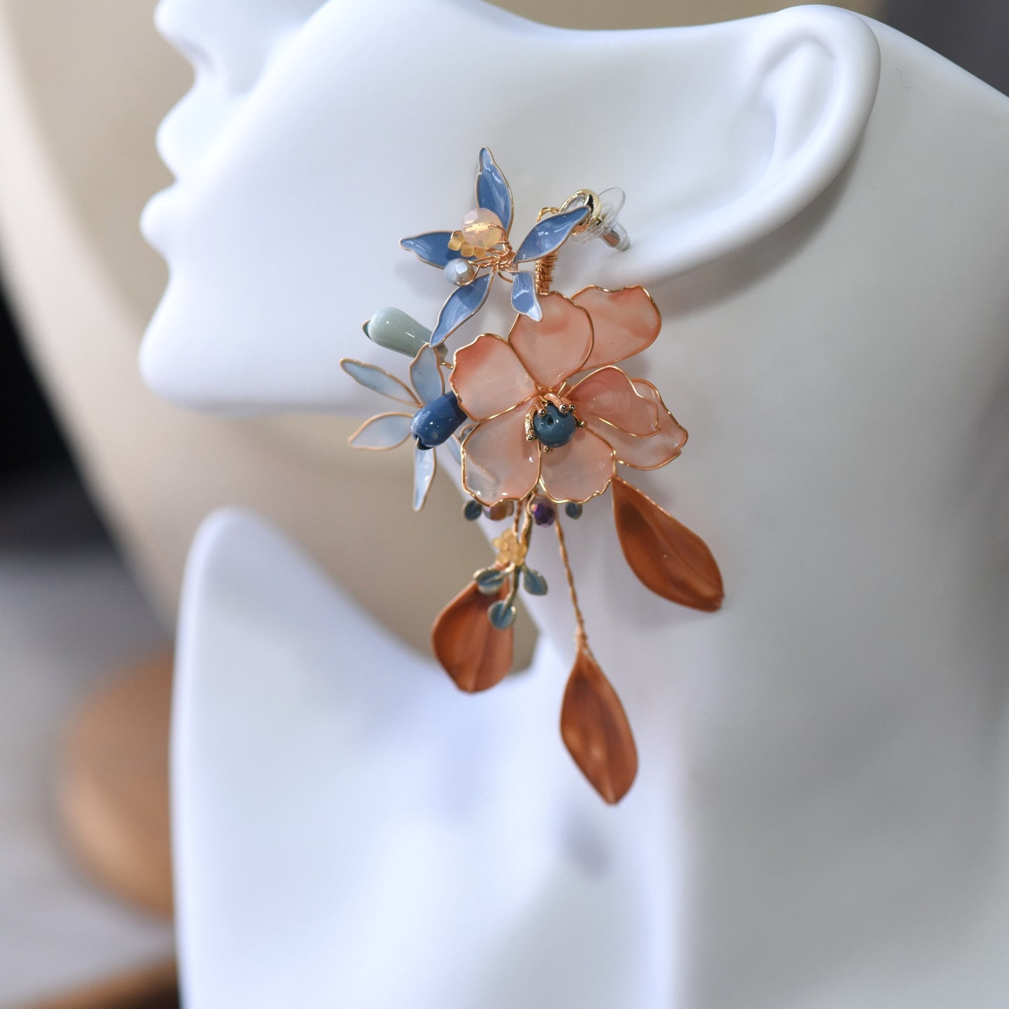 Close-up view of Nicola handcrafted floral resin earrings highlighting bead detailing, glossy petals and gold wire finish
