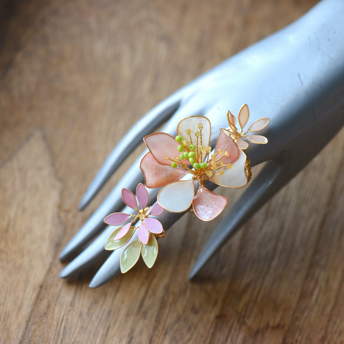 Close-up view of Sadie handcrafted floral resin ring showcasing delicate petals, bead centre and gold wire detailing