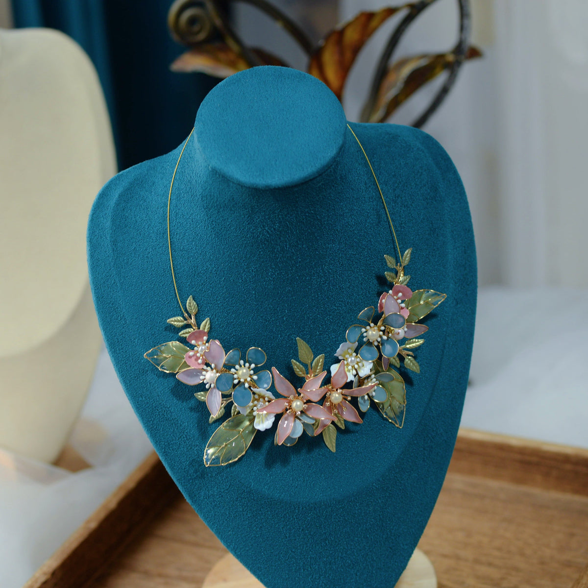 Shaylah pastel floral statement necklace displayed on a stand showing the central bloom cluster