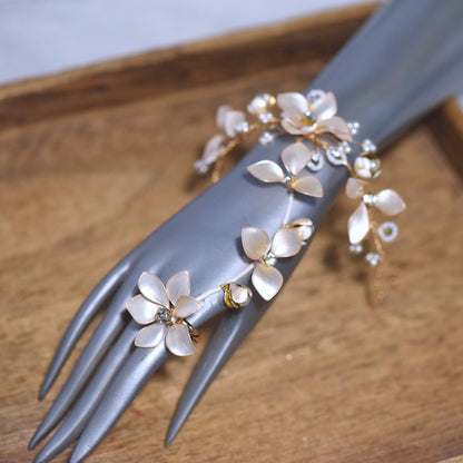 Amarille ivory resin floral haath phool with golden yellow accents worn from wrist to finger
