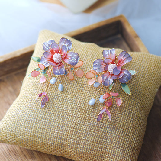 Adelei purple and pink resin floral earrings with mint and peach accents on jute cushion
