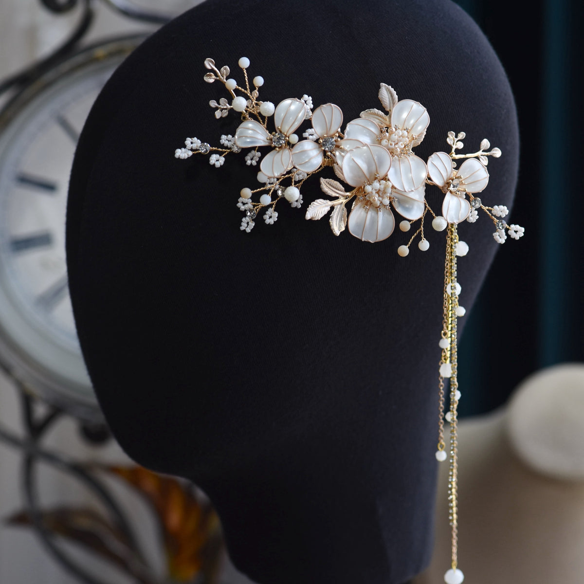 Adonia white and pearl resin floral hair vine displayed on dark stand
