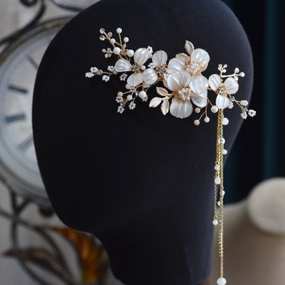 Adonia white and pearl resin floral hair vine displayed on dark stand
