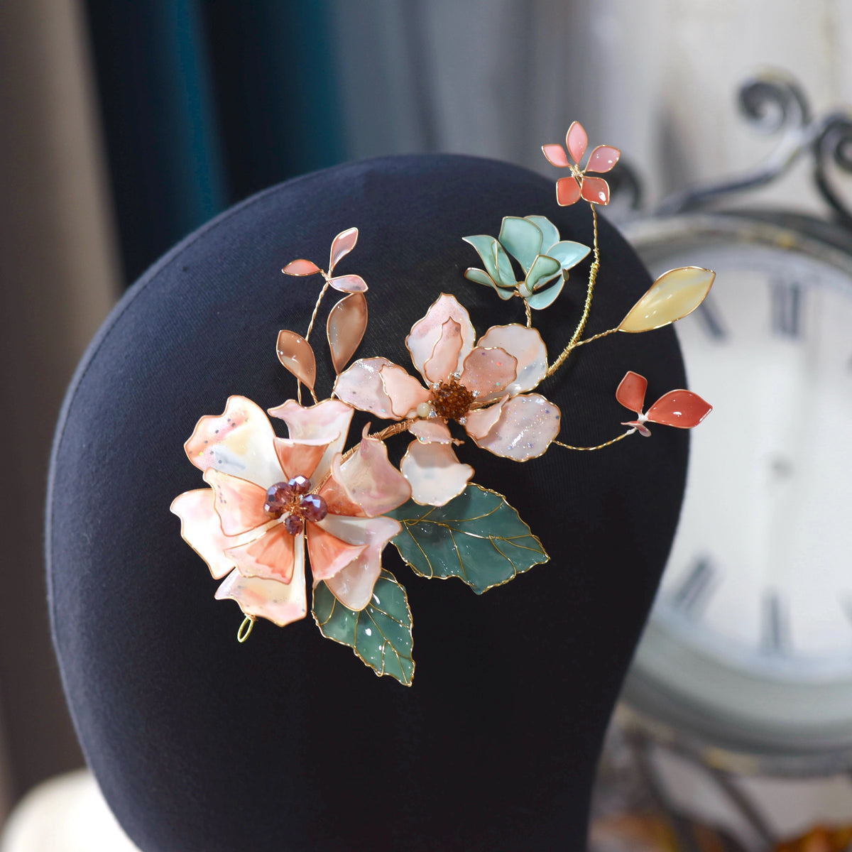 Aeris blush coral and amber resin floral hair vine detail on jute cushion
