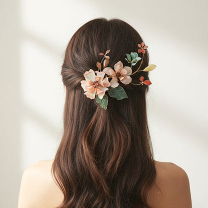 Model wearing Aeris blush and coral resin floral hair vine in a half-up hairstyle
