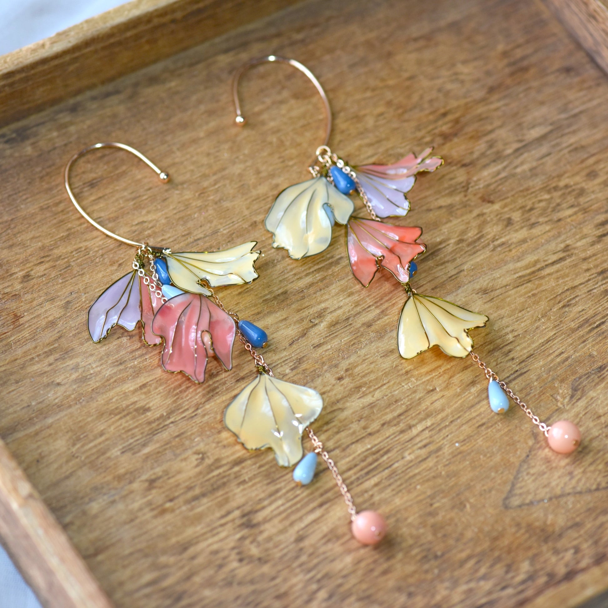 Close-up of Alicia handcrafted floral ear cuff showing glossy resin petals, pastel bead accents and intricate gold finish