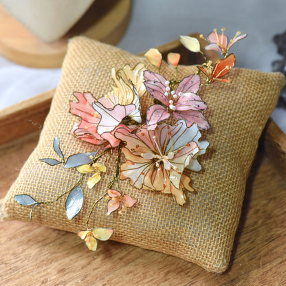 Alicia handcrafted floral hair accessory featuring blush pink and coral resin petals with gold wire detailing