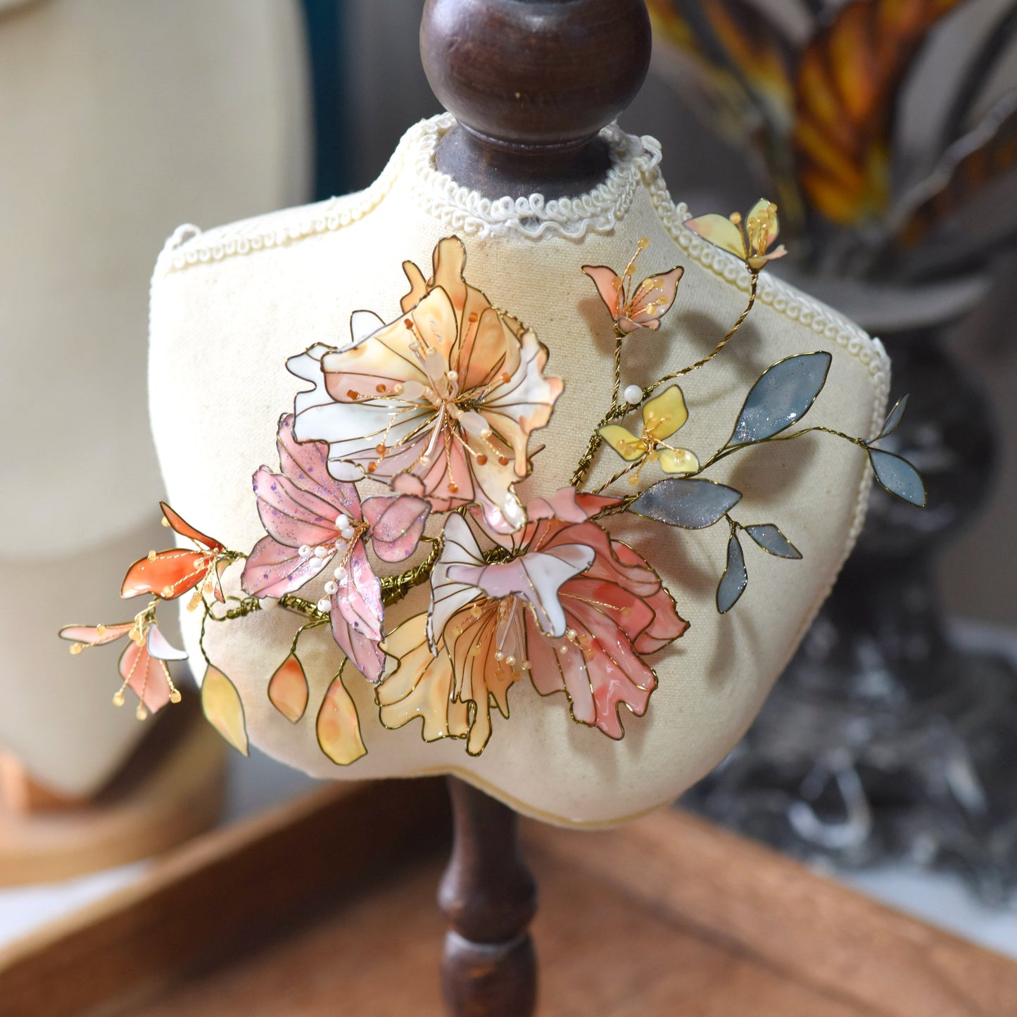 Side view of Alicia floral hair accessory showcasing layered resin petals, soft foliage accents and intricate gold wirework