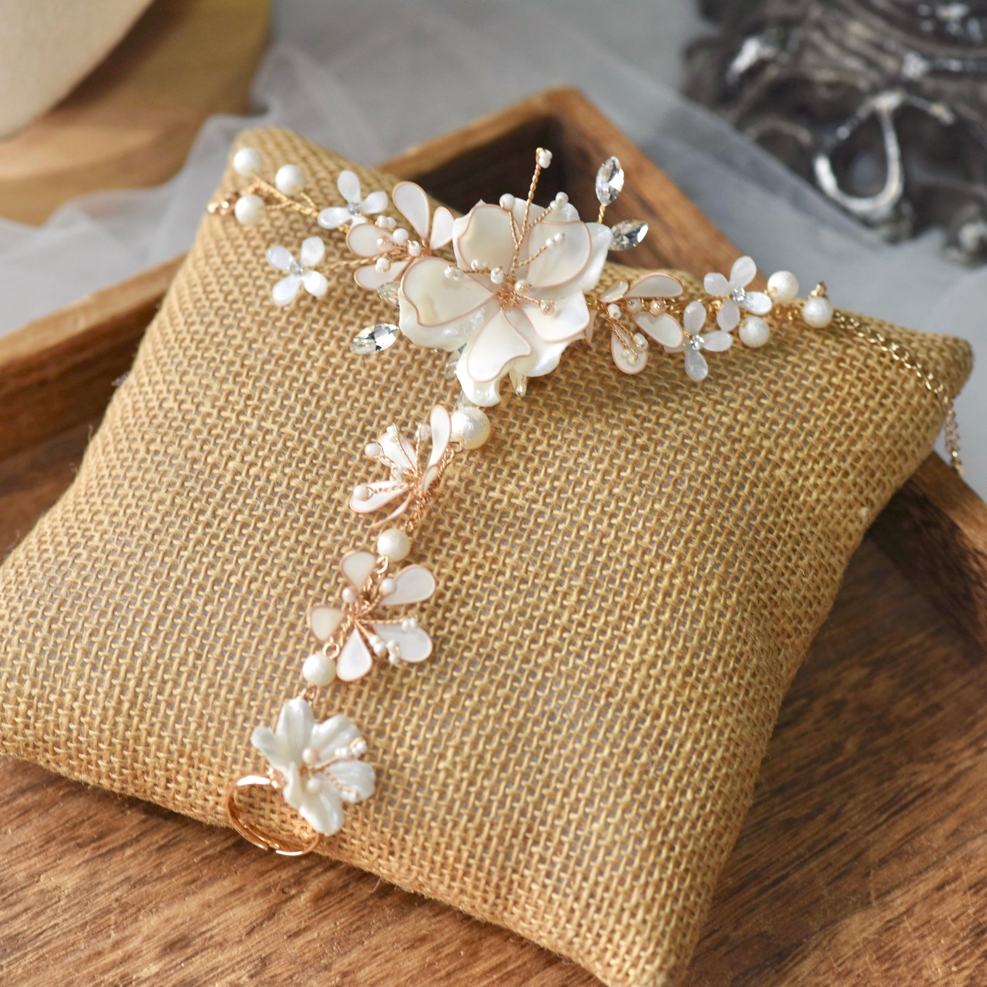 Amara handcrafted white resin floral haath phool hand harness golden accents flat lay burlap cushion
