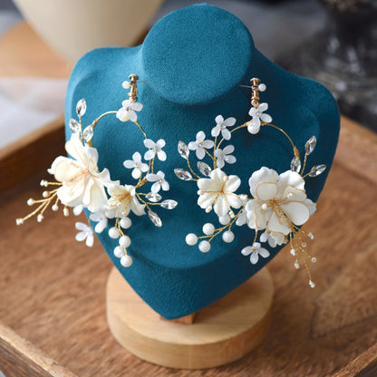 Amara handcrafted white resin floral earrings gold accents close-up detail product shot
