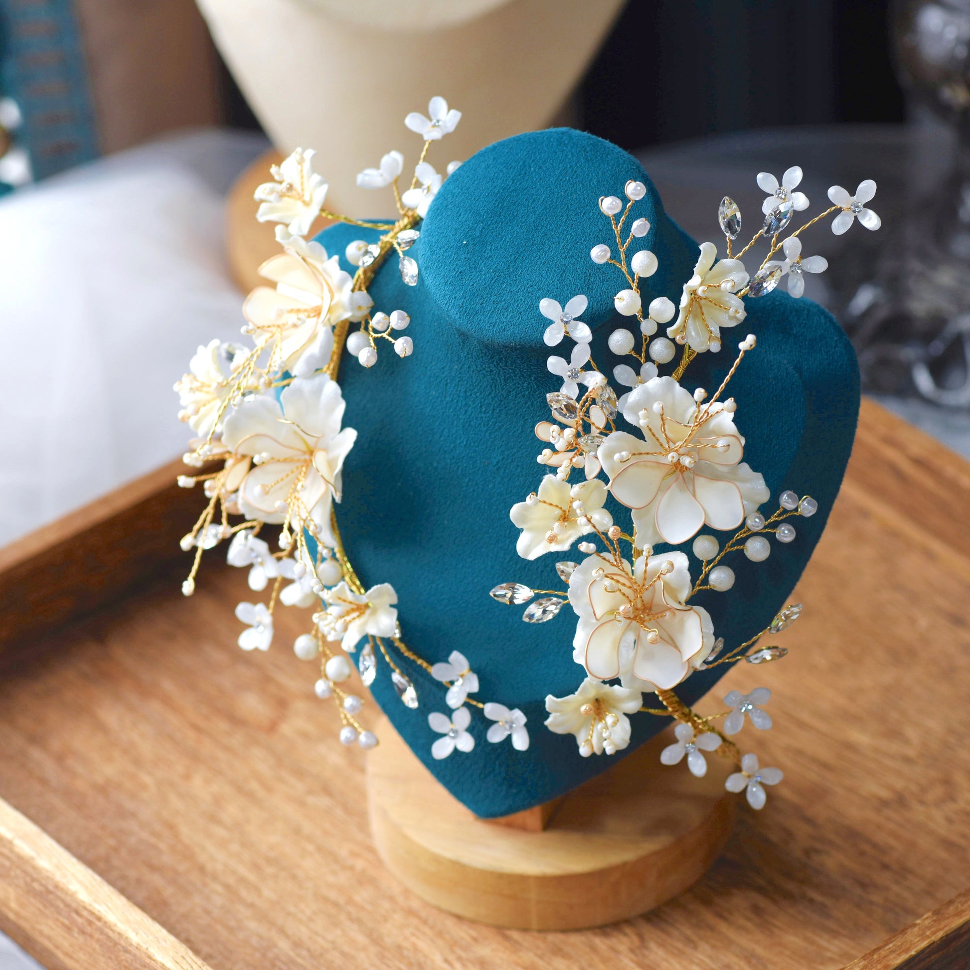 Amara handcrafted white resin floral bridal hair clips gold accents on teal bust close-up detail
