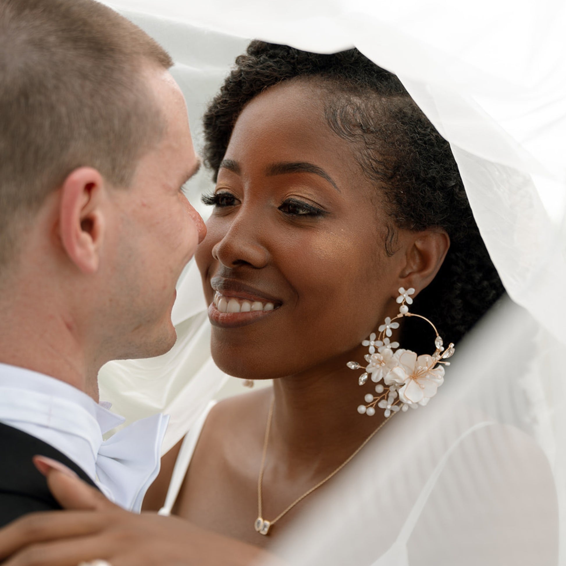 Bride wearing Amara handcrafted white resin floral statement earrings gold accents festive bridal look
