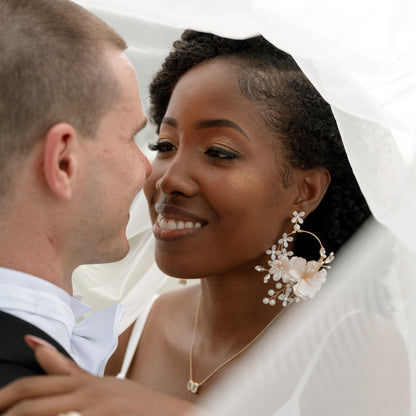 Bride wearing Amara handcrafted white resin floral statement earrings gold accents festive bridal look
