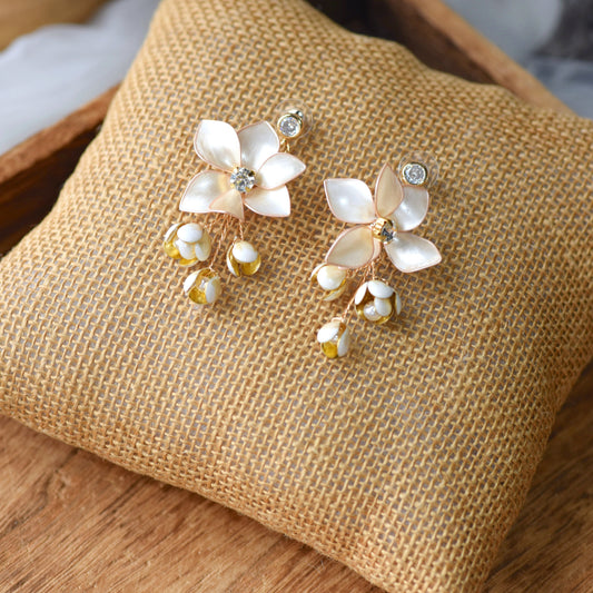 Amarille ivory resin floral earrings with crystal centres and yellow bud drops on jute cushion
