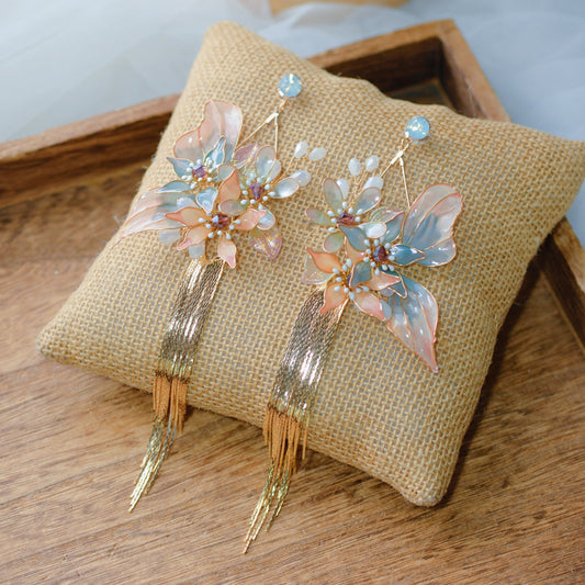 Angelica blush and blue resin floral butterfly bridal set with necklace and earrings on jute cushion
