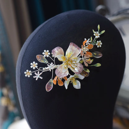 Apricot Bloom apricot and ivory resin floral hair vine displayed on dark stand
