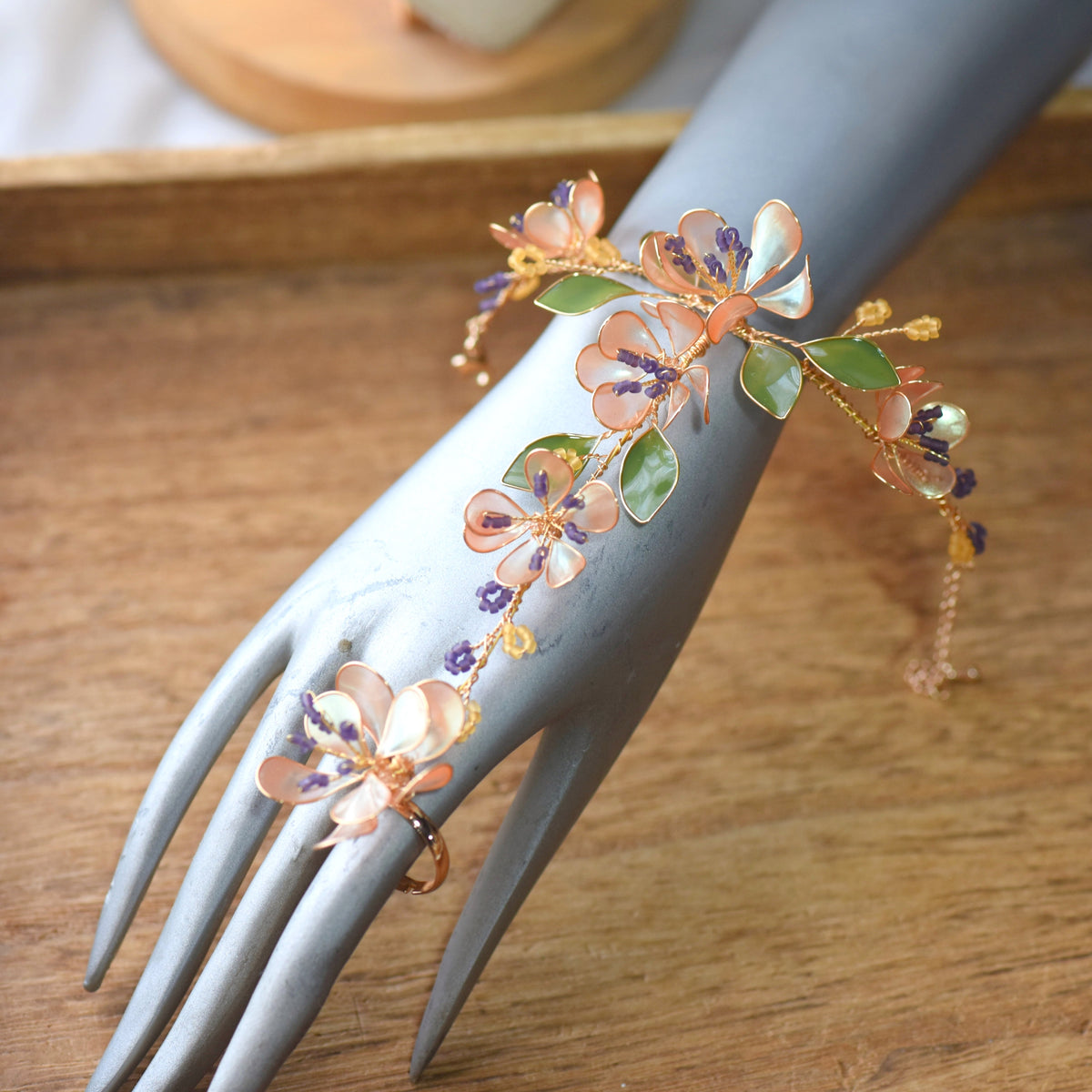 Apricot Fleur resin floral hand harness worn on the hand, showing the wrist-to-finger floral cascade