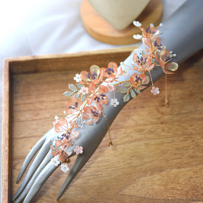 Apricot Fleur long resin floral hand harness worn on the hand, showing the full cascade from wrist to finger
