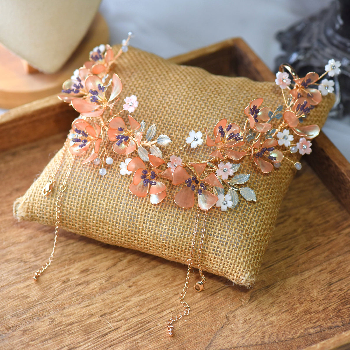 Apricot Fleur long hand harness in apricot and ivory resin florals displayed on a woven cushion
