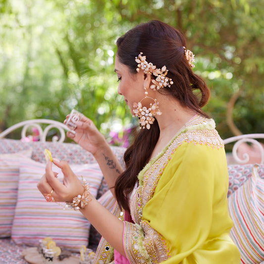 Model wearing Arabella handcrafted metal bead floral earrings golden cream beige with yellow outfit outdoor