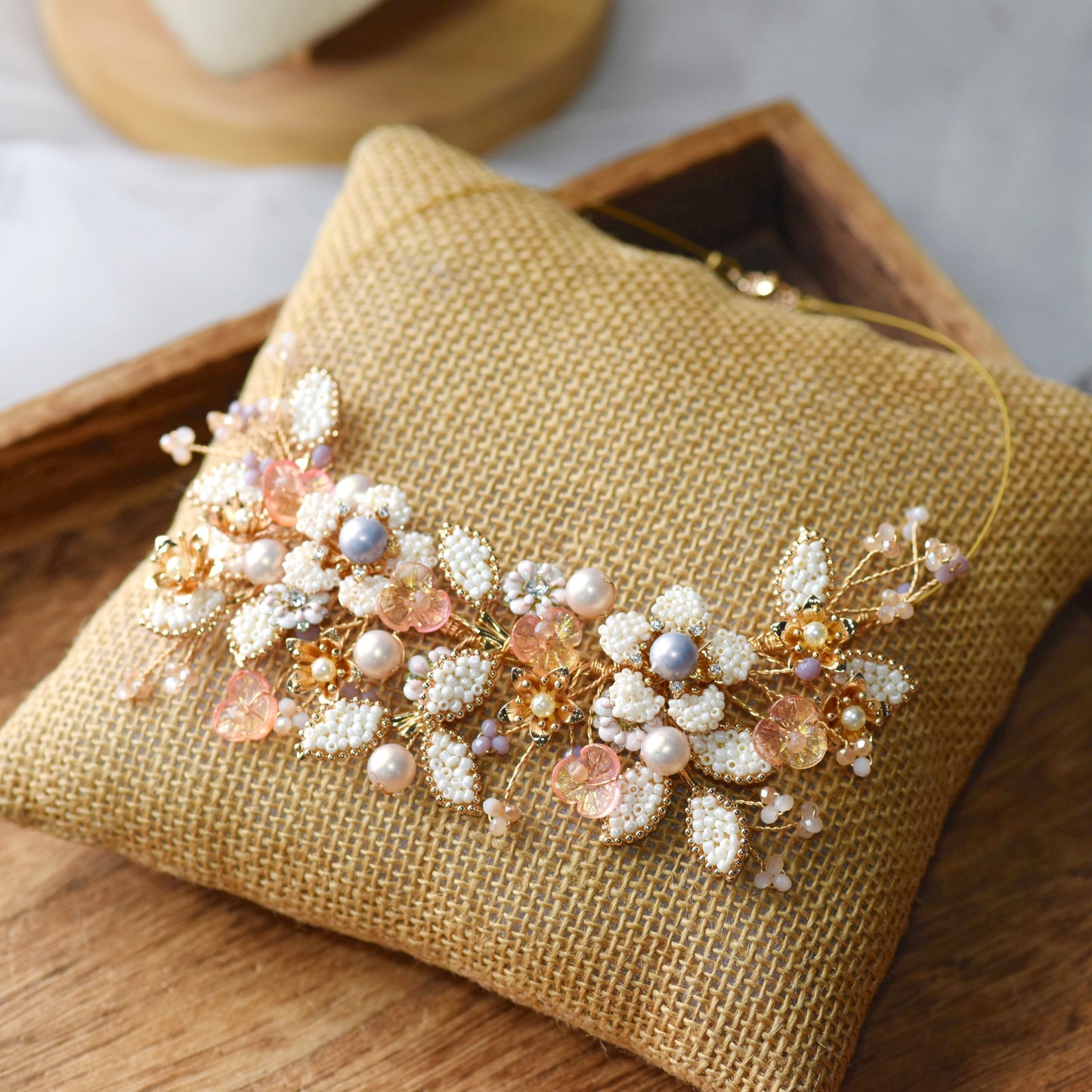 Arabella handcrafted metal bead floral necklace golden cream blush pink pearl flat lay burlap cushion
