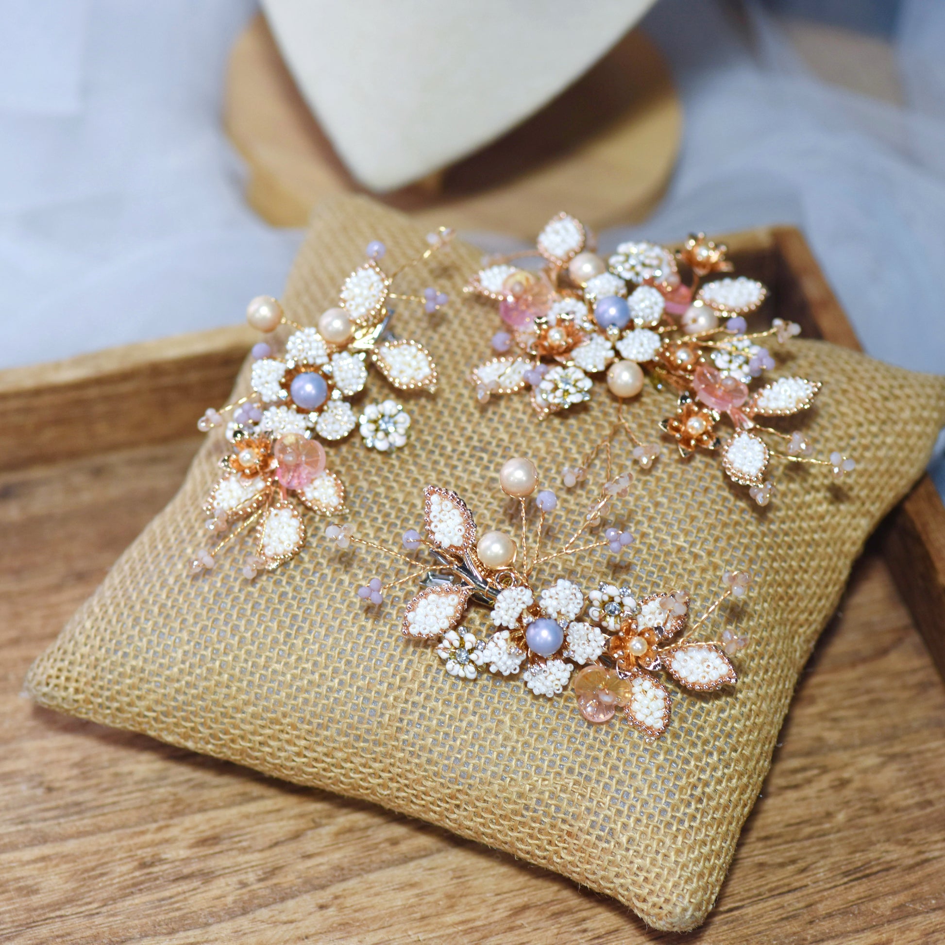 Arabella II handcrafted metal bead floral hair clips set of three golden cream beige flat lay burlap cushion
