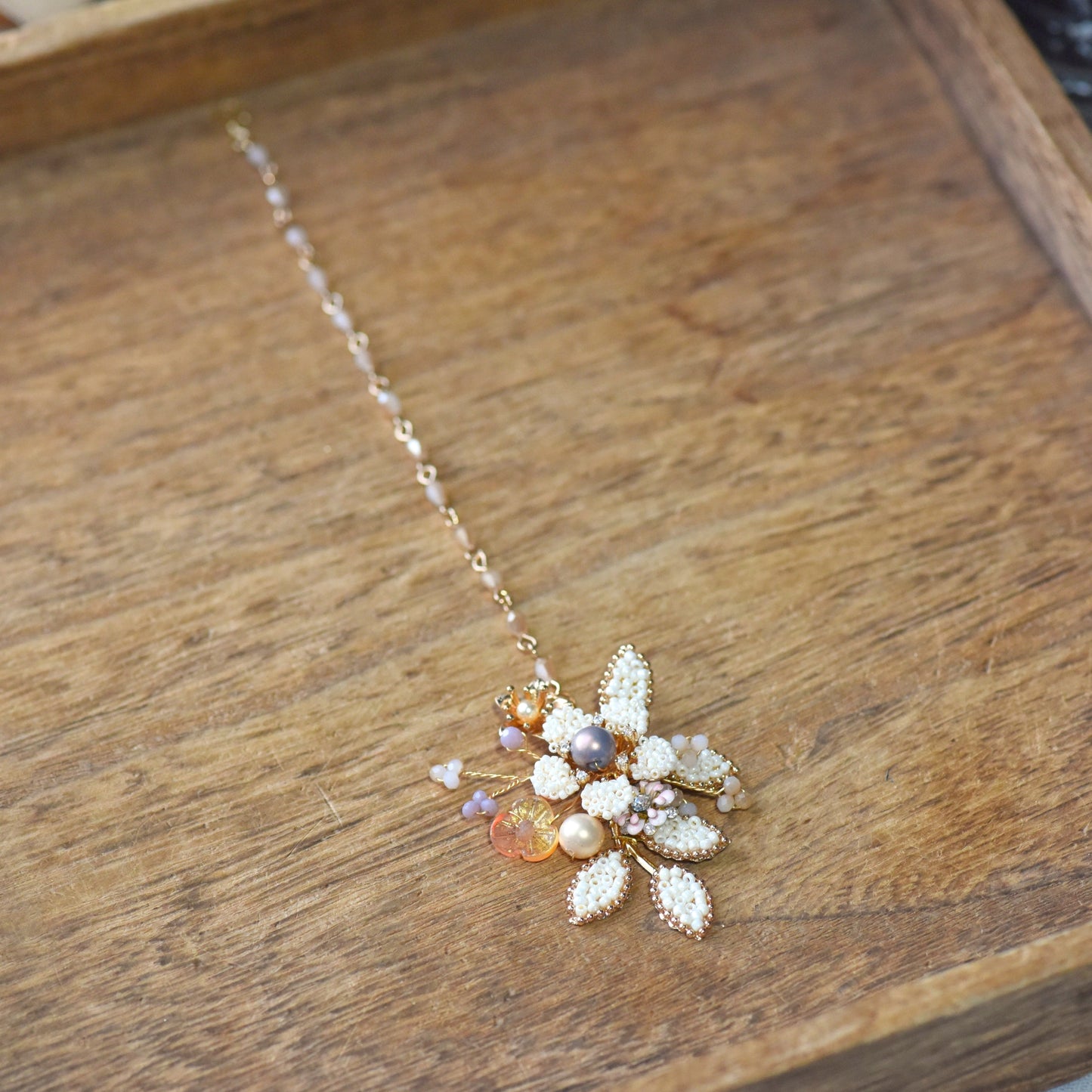 Arabella handcrafted maang tika pearl floral close-up micro-beaded petals lavender blush accents golden wire
