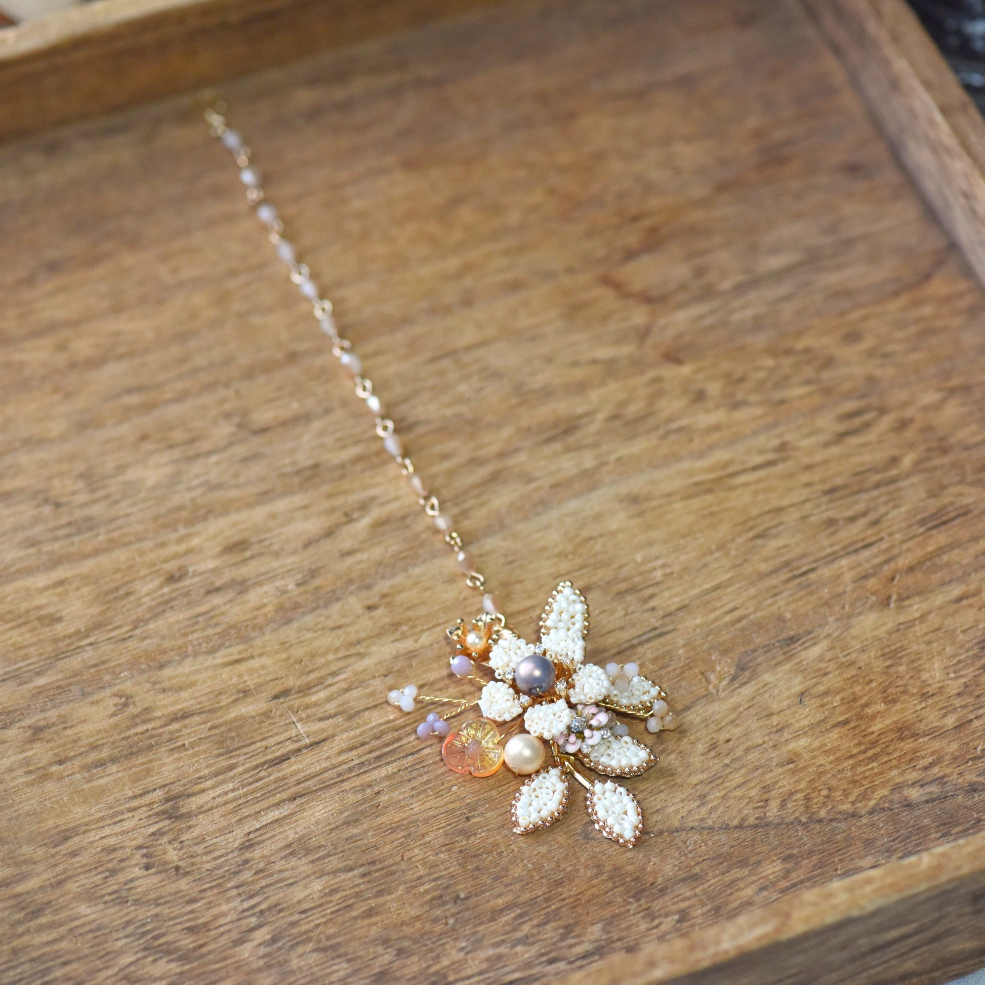 Arabella handcrafted maang tika pearl floral close-up micro-beaded petals lavender blush accents golden wire

