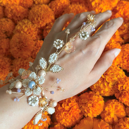 Arabella handcrafted metal bead floral haath phool hand harness golden cream white pearl beads on hand marigold background