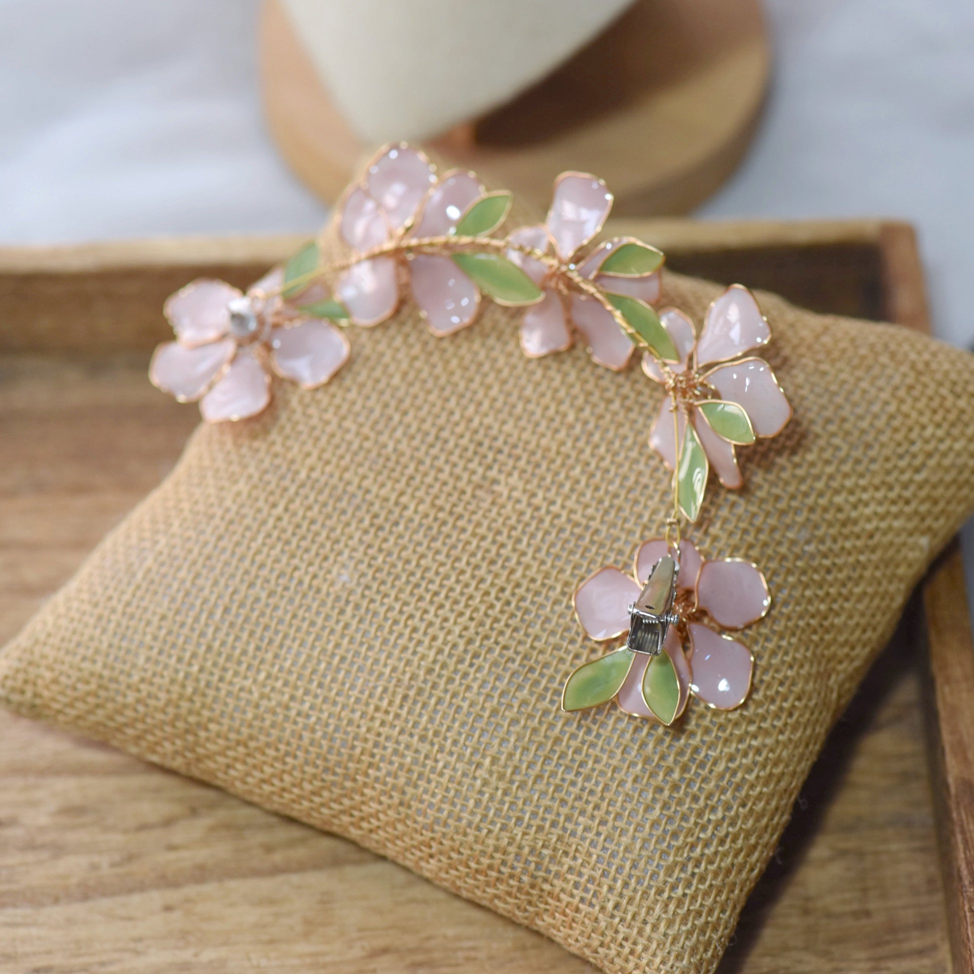 Close-up of Aubri pink resin floral earrings and hair harness chain detail
