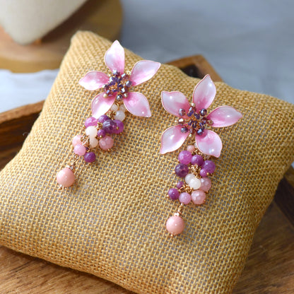 Aurelia ombré blush pink resin floral earrings with lilac bead cascade on a jute cushion
