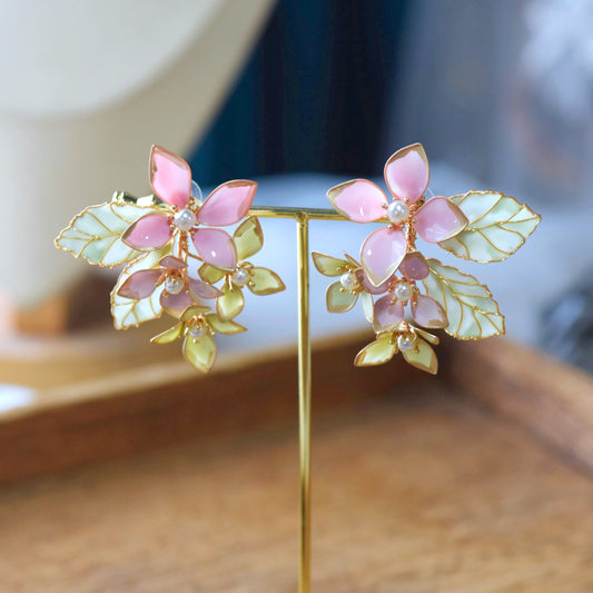 Aurora mint green and lilac pink resin floral earrings worn with hair in a low bun
