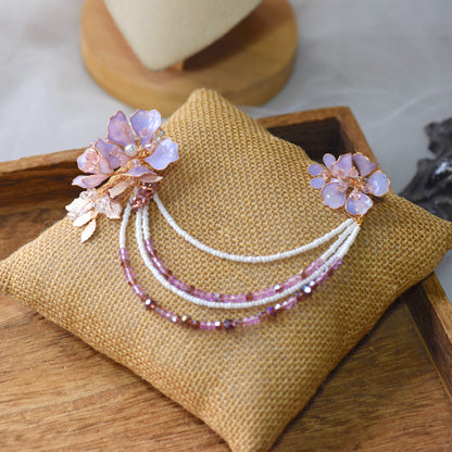 Belle lavender resin floral earrings with detachable hair harness on jute cushion
