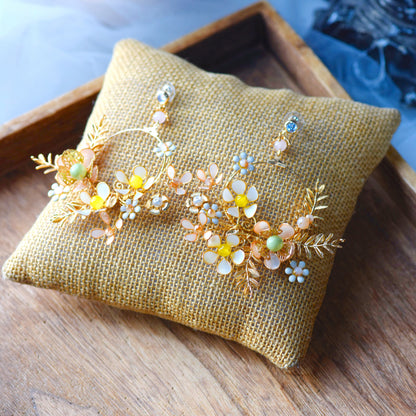 Betty yellow gold and green resin floral long drop earrings on an embroidered cushion
