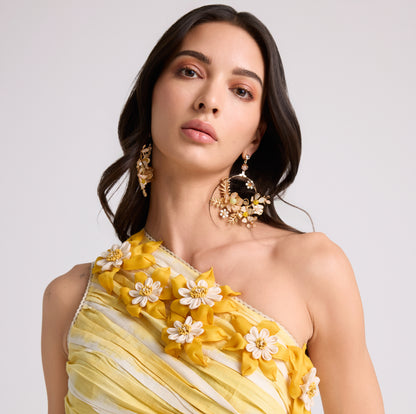 Betty yellow and gold resin floral long drop earrings worn with a yellow off-shoulder outfit
