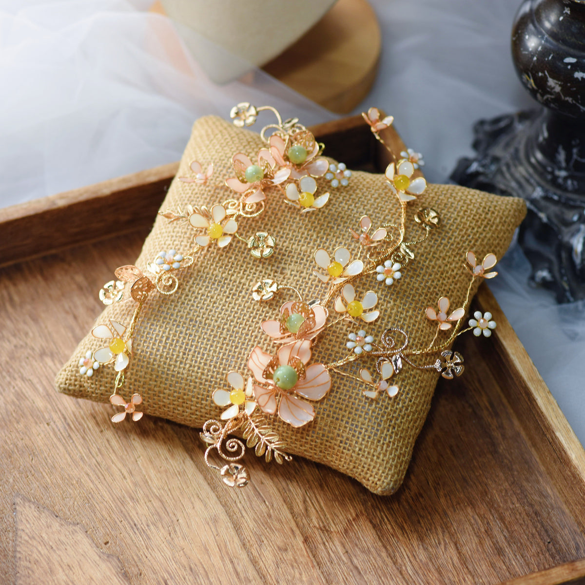 Betty yellow and gold resin floral bridal set with earrings and two hair vines on an embroidered cushion
