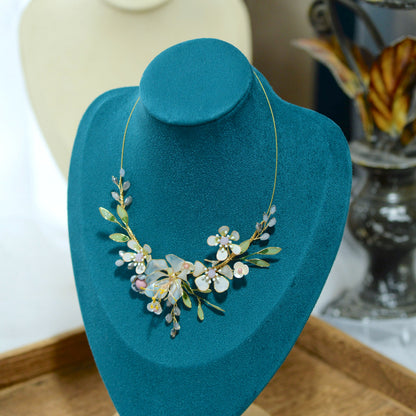 Bluesette handcrafted blue green resin floral necklace white gold blooms on teal bust close-up detail
