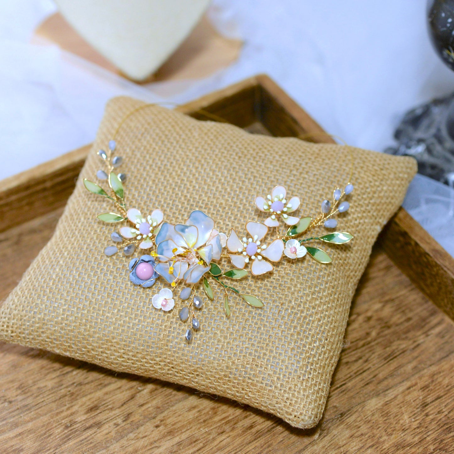 Bluesette handcrafted blue green white gold resin floral statement necklace flat lay burlap cushion botanical
