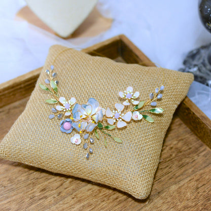 Bluesette handcrafted blue green white gold resin floral statement necklace flat lay burlap cushion botanical
