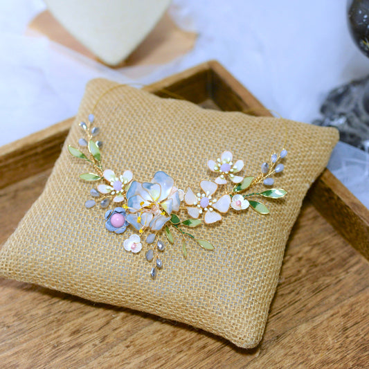 Bluesette handcrafted blue green white gold resin floral statement necklace flat lay burlap cushion botanical
