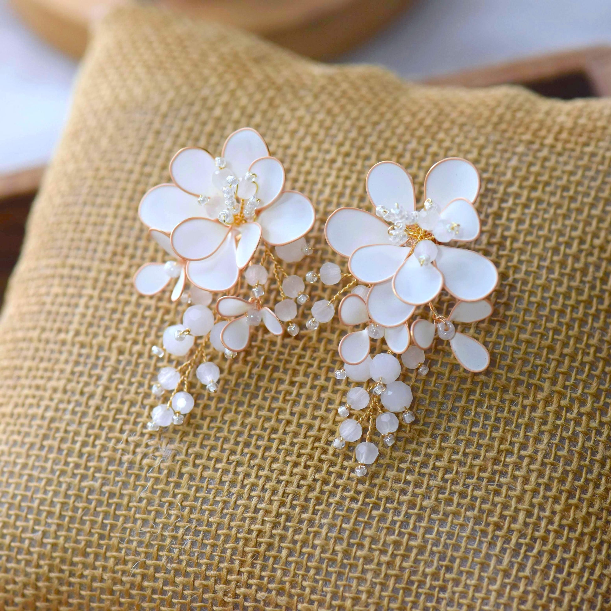 Calla handcrafted white ivory resin floral drop earrings rose gold wire crystal centre opalescent bead drops flat lay burlap
