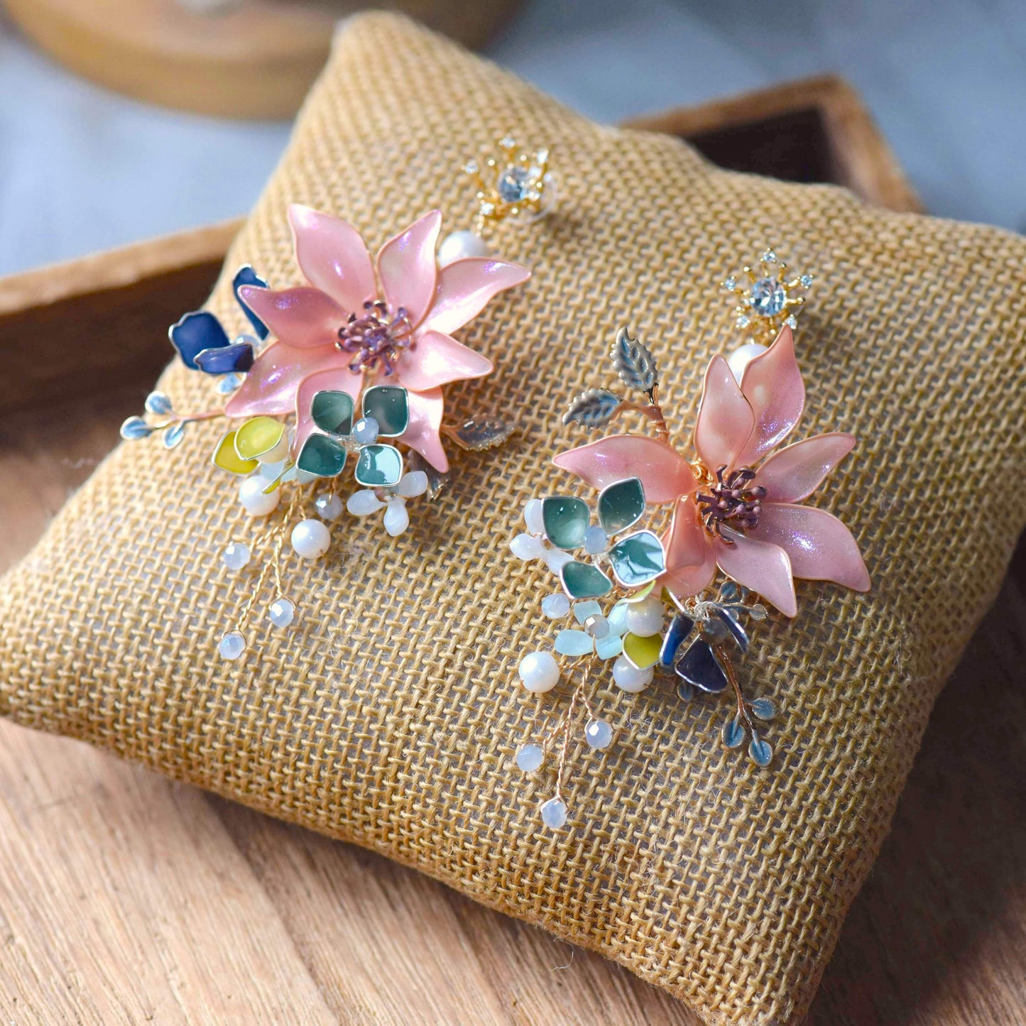 Camille handcrafted blush pink resin floral drop earrings teal blue opalescent bead drops gold wire flat lay burlap
