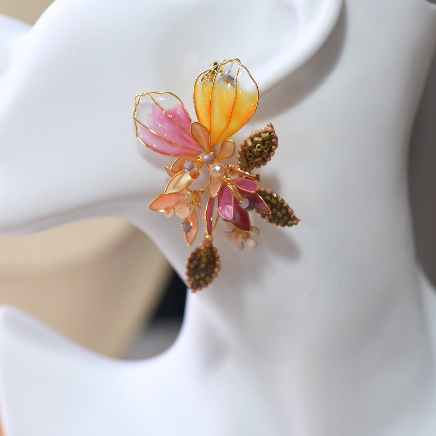 Close up of Catriona drop earrings with translucent pink and orange floral petals