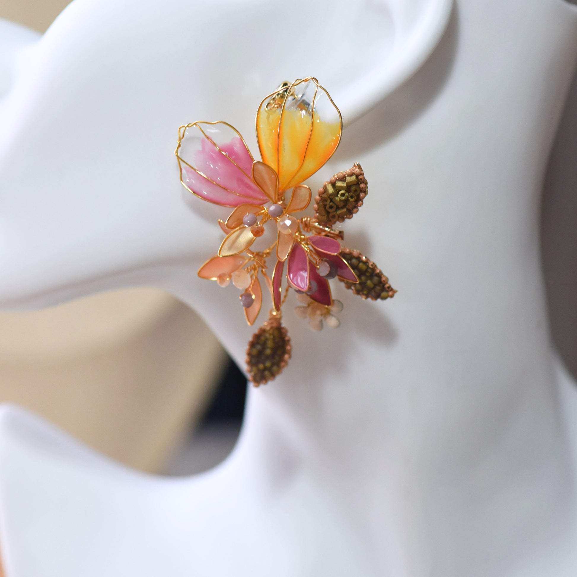 Close up of Catriona drop earrings with translucent pink and orange floral petals