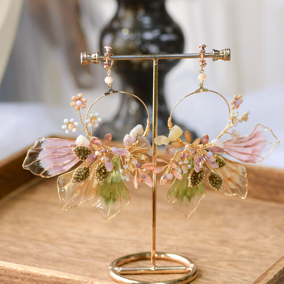 Catriona lavender resin floral earrings on a gold display stand showing petal and leaf detail
